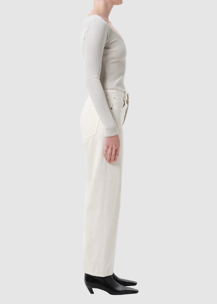 Person wearing a white long-sleeve top and pants on a white background